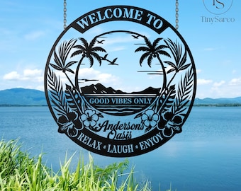 May include: Black metal sign with a circular design, featuring palm trees, mountains, and the text "WELCOME TO" and "GOOD VIBES ONLY." The sign also includes the name "Anderson's Oasis" and the words "RELAX * LAUGH * ENJOY."
