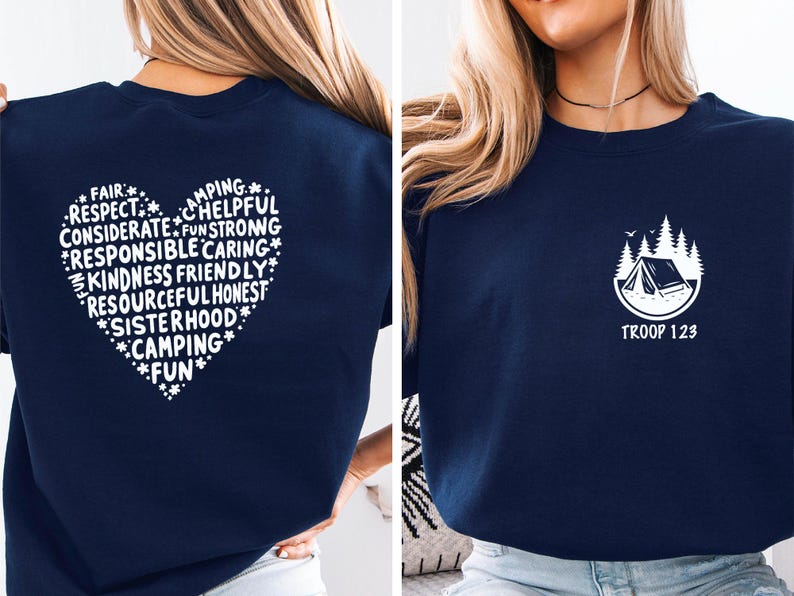 May include: Navy blue sweatshirt with a white heart-shaped design on the back, filled with words like "Respect" and "Kindness." The front features a small white graphic of a tent and trees with the text "Troop 123."