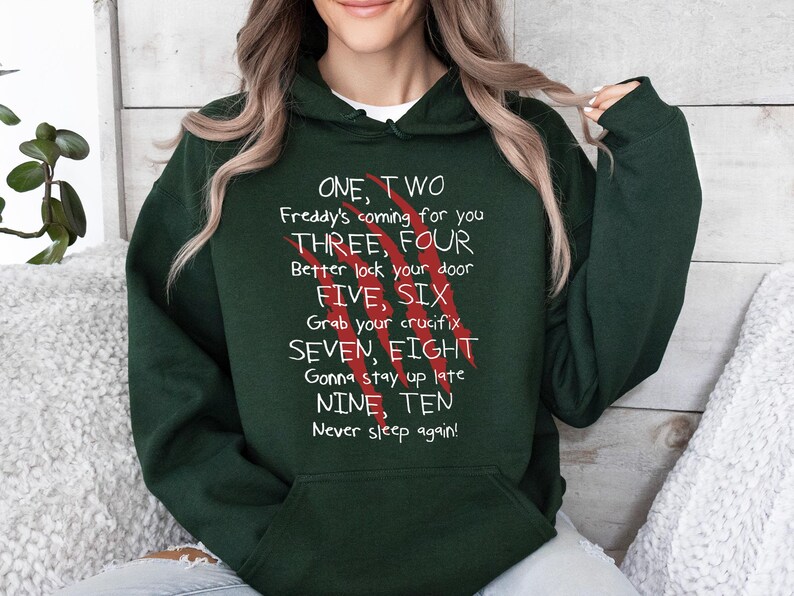 May include: Dark green hoodie with white text and red claw marks. The text reads "ONE, TWO Freddy's coming for you THREE, FOUR Better lock your door FIVE, SIX Grab your crucifix SEVEN, EIGHT Gonna stay up late NINE, TEN Never sleep again!"