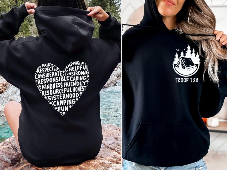 May include: Black hoodies with white graphics. One features a heart-shaped design with words like "Camping" and "Kindness." The other displays a tent and trees with "TROOP 123" below. Both have a front pocket and hood.