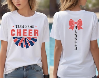 May include: White t-shirt with the word "CHEER" in red and blue, and the text "TEAM NAME" above it. The back of the shirt has a red bow graphic and the name "HARPER" printed vertically.