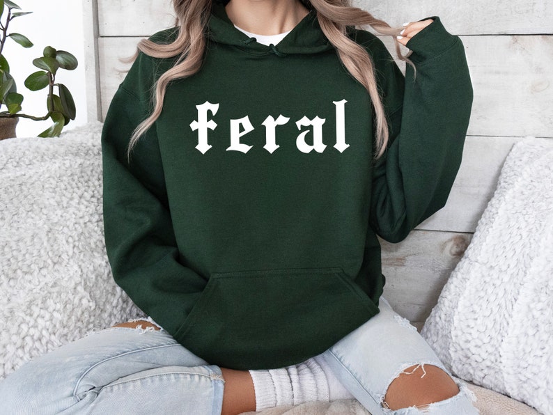 May include: A dark green hooded sweatshirt with the word "feral" printed in white on the front.