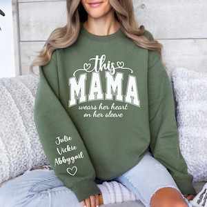 Custom This Mama Wears Her Heart On Her Sleeve Hoodie, Personalized Mom Sweatshirt With Kids Names, Cute Momma Outfit, Mothers Day Gifts