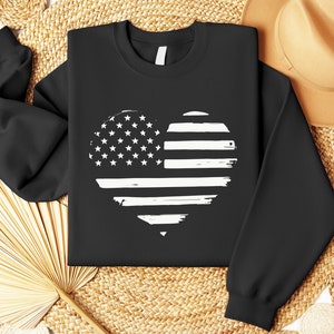 May include: Black sweatshirt with a white distressed American flag heart design.