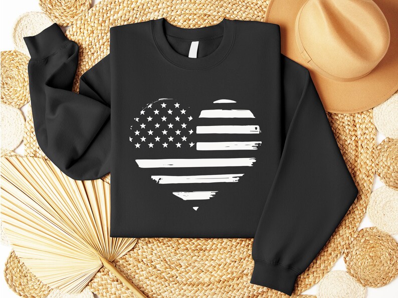 May include: Black sweatshirt with a white distressed American flag heart design.