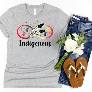 May include: Grey t-shirt with an infinity symbol design featuring a feather, handprints, and the word "Indigenous".