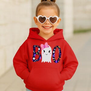 May include: A bright red hooded sweatshirt featuring a graphic print on the front. The design displays the word BOO in large letters, with a white ghost wearing a pink bow replacing the letter O. The letters B and O have a dark purple pattern.