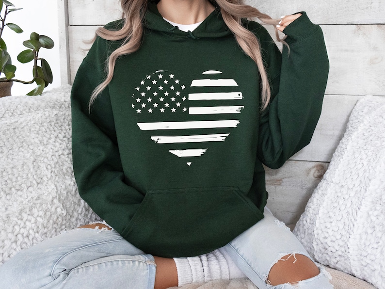 May include: A dark green hooded sweatshirt with a white distressed American flag heart design.