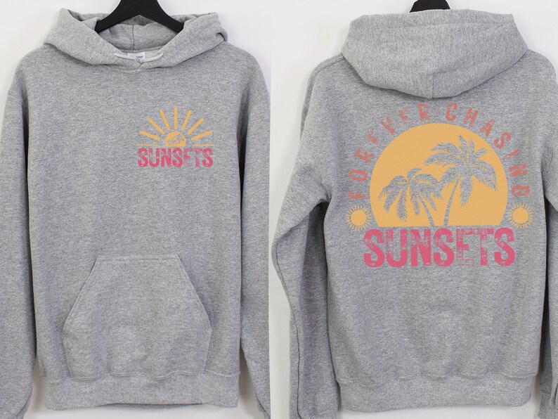 May include: Gray hooded sweatshirt with a graphic of a sunset and palm trees on the back. The text "FOREVER CHASING SUNSETS" is printed in pink and yellow on the back. The front of the sweatshirt has a smaller graphic of a sunset with the text "SUNSETS" printed in pink and yellow.