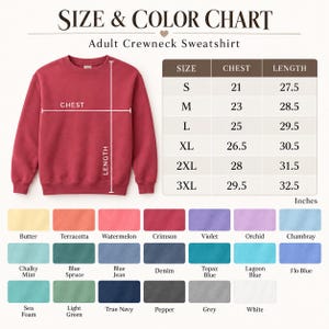 K&ouml;nnte beinhalten: Ein karmesinrotes Sweatshirt mit Rundhalsausschnitt, dargestellt mit einer Gr&ouml;&szlig;en- und Farbtabelle. Die Tabelle listet Brust- und L&auml;ngenma&szlig;e in Zoll f&uuml;r die Gr&ouml;&szlig;en S bis 3XL auf. Darunter zeigt ein Raster einundzwanzig Farbfelder mit Bezeichnungen wie Butter, Terracotta, Watermelon, Crimson, Violet, Orchid, Chambray, Chalky Mint, Blue Spruce, Blue Jean, Denim, Topaz Blue, Lagoon Blue, Flo Blue, Sea Foam, Light Green, True Navy, Pepper, Grey und White.