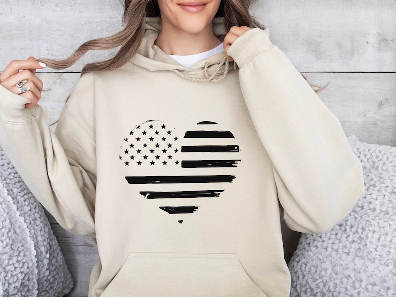 May include: A beige hoodie featuring a black and white heart-shaped American flag design.