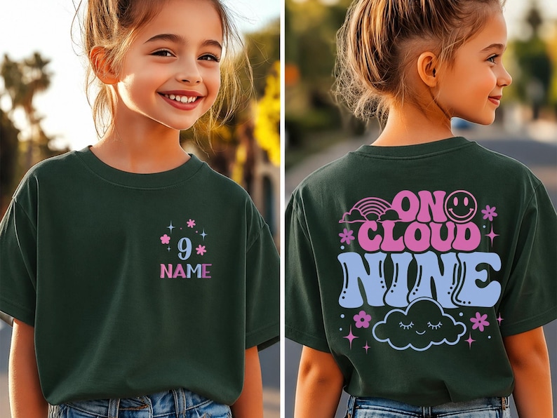 May include: Dark green t-shirt with the text "9" and "NAME" in pink and blue, with floral accents. The back of the shirt features the phrase "ON CLOUD NINE" with a rainbow, smiley face, cloud, and floral designs.