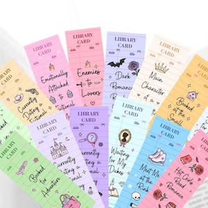 May include: A collection of colorful bookmarks with the words "Library Card" at the top. Each bookmark features a different theme, including "Booked in a Galaxy," "Enemies to Lovers," and "Hot Girls Read Romance."