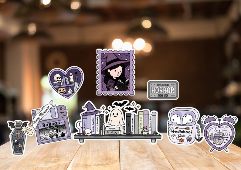 May include: A selection of Halloween-themed stickers. Designs include a witch reading, a ghost, and the word "HORROR". The stickers are in purple, black, and white, with a cartoon style. Measurements are in cm.