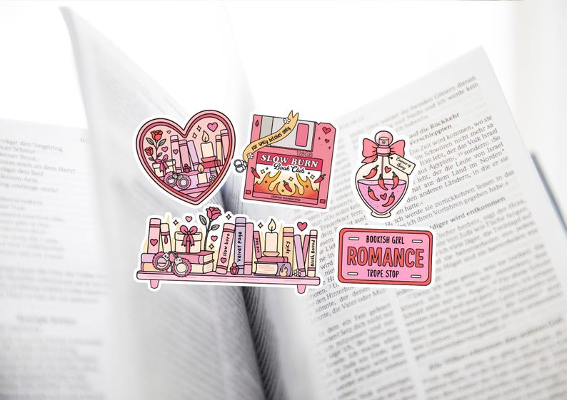 May include: A collection of pink and red stickers with a bookish theme. Designs include a heart with books and candles, a floppy disk with flames, a potion bottle with chili peppers, and a shelf of books. The text includes "Slow Burn Book Club" and "Bookish Girl Romance".