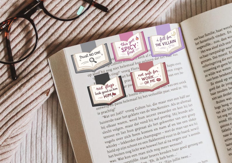 Puede incluir: P&aacute;gina de libro con varios marcadores decorativos. Cada marcador tiene la forma de un libro abierto y presenta textos como "trust NO ONE" y "this got SPICY fast". Los marcadores son de varios colores, incluyendo rosa, morado y rojo.