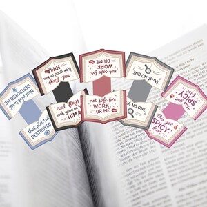 Puede incluir: Un conjunto de etiquetas decorativas con forma de libro con frases como "red flags look good on him" y "this got spicy fast". Las etiquetas, en rojo, rosa, azul y gris, est&aacute;n colocadas sobre un libro abierto.