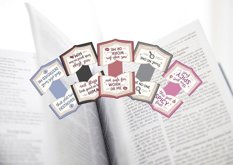 Puede incluir: Un conjunto de etiquetas decorativas con forma de libro con frases como "red flags look good on him" y "this got spicy fast". Las etiquetas, en rojo, rosa, azul y gris, est&aacute;n colocadas sobre un libro abierto.