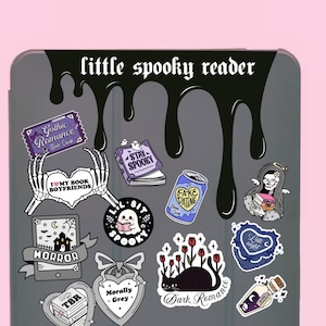 Pode incluir: Uma cole&ccedil;&atilde;o de autocolantes com tema assustador num fundo cinzento, com as palavras "little spooky reader" no topo. Os autocolantes apresentam romance g&oacute;tico, fantasmas, livros e as frases "I love my book boyfriends" e "Fake Dating".
