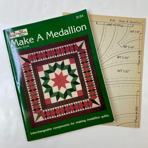May include: A green book titled "Make A Medallion" by Kathy Cook, with a quilt pattern on the cover. The quilt design features a red star and green and red diamond shapes. A pattern sheet is next to the book.