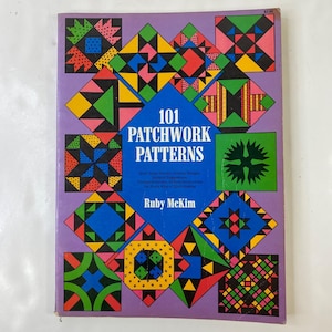 May include: A vintage book titled "101 Patchwork Patterns" by Ruby McKim. The cover displays a purple background with colourful geometric quilt block designs. The book includes instructions for quilt making.