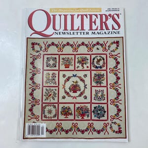 May include: A copy of Quilter's Newsletter Magazine, April 2000, featuring a quilt design on the cover. The quilt design has a cream background with red floral borders and squares with floral arrangements. The magazine title is in red.