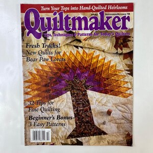 Puede incluir: La portada de la revista Quiltmaker, n.º 63, presenta un diseño de edredón en forma de árbol en tonos morado, naranja y marrón. El título de la revista está en una fuente grande de color púrpura, con el texto "Turn Your Tops into Hand-Quilted Heirlooms". El texto adicional incluye "Fresh Tracks! New Quilts for Bear Paw Lovers".