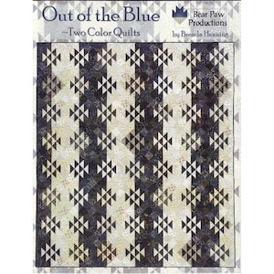 May include: A quilt pattern named "Out of the Blue" with a two-colour design. The quilt displays alternating vertical stripes of cream and navy blue, decorated with geometric shapes. The pattern is by Brenda Henning and produced by Bear Paw Productions.