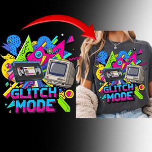 Puede incluir: Camiseta gris oscuro con un diseño retro. Presenta una cinta VHS, un monitor de ordenador vintage y el texto "GLITCH MODE" en una fuente colorida y pixelada. El diseño incluye formas geométricas en colores brillantes.