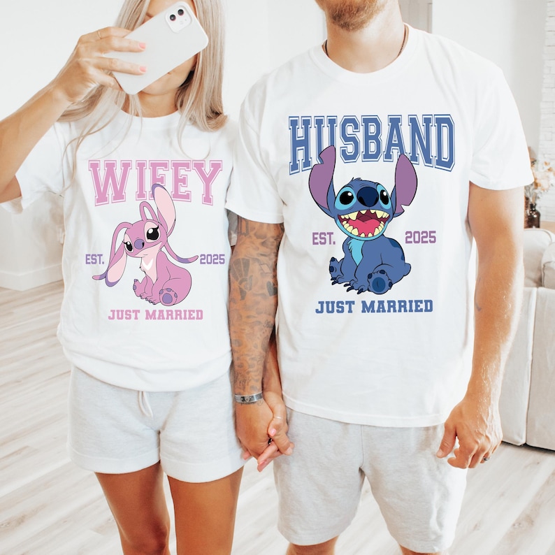 Puede incluir: Camisetas blancas con gr&aacute;ficos a juego. Una camiseta dice "Wifey" con un personaje de dibujos animados rosa y el texto "Just Married" y "Est. 2025". La otra camiseta dice "Husband" con un personaje de dibujos animados azul y el texto "Just Married" y "Est. 2025".