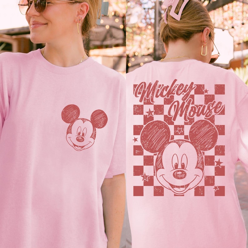 Puede incluir: Camiseta rosa claro con un dise&ntilde;o desgastado de Mickey Mouse en la parte delantera y trasera. El dise&ntilde;o trasero incluye las palabras "Mickey Mouse" sobre un patr&oacute;n de cuadros con estrellas. Un dise&ntilde;o cl&aacute;sico y divertido.