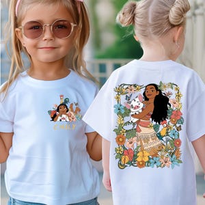 May include: White t-shirts with colorful graphic designs. One shirt features a cartoon illustration of a girl with the name "EMILY" below. The other shirt displays a character holding a pig, surrounded by flowers and birds.