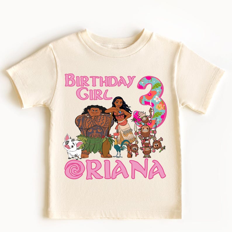 Op de afbeelding: Cr&egrave;mekleurig peuter-T-shirt met een kleurrijke afbeelding van tekenfilmfiguren. Het ontwerp bevat de tekst "BIRTHDAY GIRL" en het nummer "3" in roze, samen met een naam. Een leuk en feestelijk verjaardags-T-shirt.