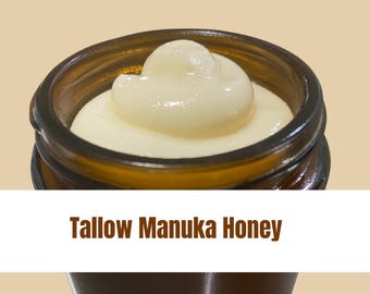 May include: A close-up of a glass jar filled with a thick, creamy, light yellow substance. The jar has a brown lid and the text "Tallow Manuka Honey" is printed on the label.