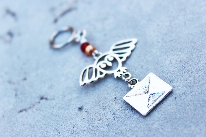Peut inclure: Porte-cl&eacute;s hibou argent&eacute; avec des perles rouges et dor&eacute;es et un charme enveloppe argent&eacute;.