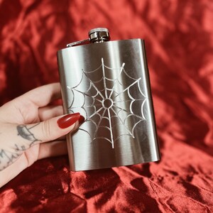 Stainless steel flask hand engraved with an American traditional tattoo style spider web.