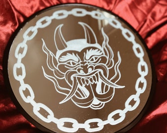 Hand engraved circle shaped wall hanging decor mirror in an American traditional tattoo style of a devil face framed in chain