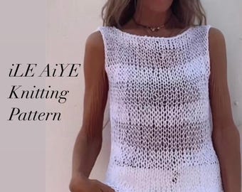 May include: A white crochet tank top with a loose, open weave. The top is sleeveless and has a scoop neck. The model is wearing the top with white pants.