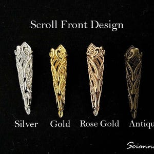 May include: Four ornate finger armor designs in silver, gold, rose gold, and antique finishes are displayed against a black background. The text "Scroll Front Design" is at the top, with the color names below each piece.