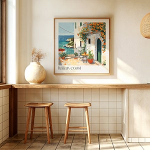May include: A framed print of a painting depicting a colorful Italian coastal scene with a white building, a balcony, and orange flowers. The text "Italian Coast" is printed below the image.
