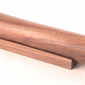 May include: A wooden kaleidoscope with a brown finish. The kaleidoscope is resting on a wooden stand.