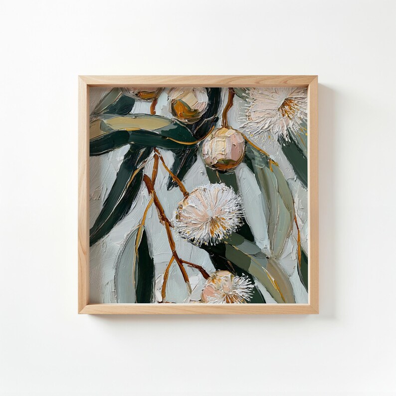 May include: Square framed painting of eucalyptus branches with green leaves and white, fluffy flowers. The artwork has a textured, impasto style, with visible brushstrokes. The frame is made of light-colored wood.
