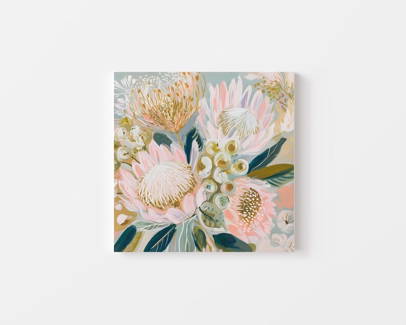 May include: Square canvas art featuring a floral arrangement. The artwork showcases large protea flowers in shades of pink, peach, and gold, with green and blue-green leaves. The background is a soft, muted blue-green.