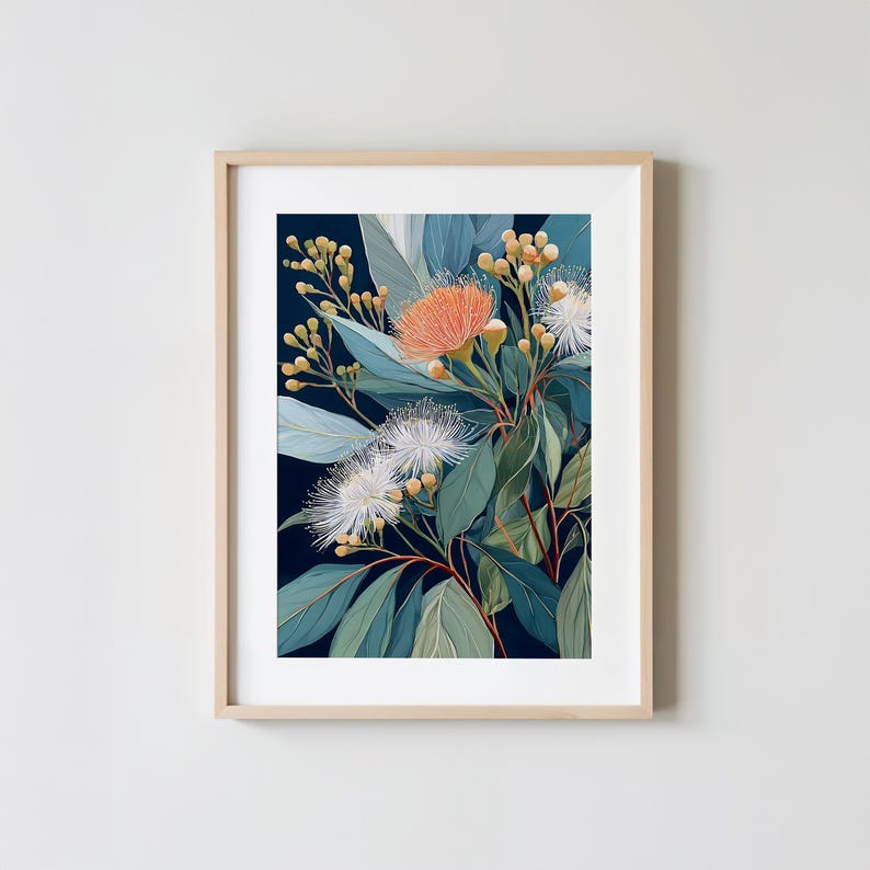 Puede incluir: Una impresi&oacute;n bot&aacute;nica enmarcada que presenta un arreglo floral. La obra de arte muestra una flor naranja, flores blancas y esponjosas y hojas verdes y verde azulado sobre un fondo azul oscuro. La impresi&oacute;n est&aacute; encerrada en un marco de madera de color claro.