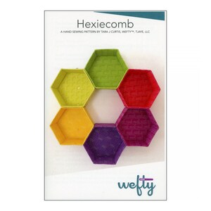 May include: A hand sewing pattern titled "Hexiecomb" featuring six colorful, hexagonal fabric containers. The containers are arranged in a flower-like pattern, with each hexagon displaying a different color and pattern. The Wefty logo is visible.