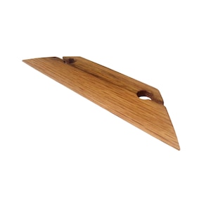 May include: A wooden tool with a triangular shape and a hole in the center. The tool is made of light brown wood with a natural grain pattern.