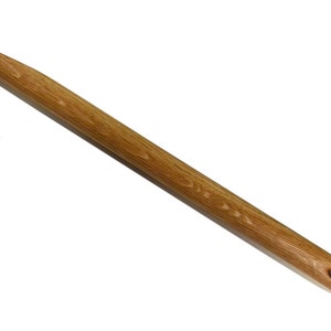 Puede incluir: Un gancho de ganchillo de madera largo con un acabado natural. El gancho es liso y tiene una ligera curva en el extremo.