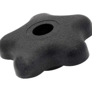 Puede incluir: Pomo de plástico negro en forma de estrella con un agujero redondo en el centro.