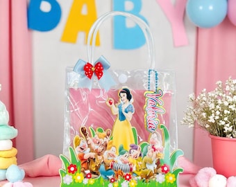 May include: Clear plastic tote bag with a Snow White theme. The bag features a colorful illustration of Snow White and the Seven Dwarfs, a blue bow with red accents, and a tag that says "Valeria". The bag is designed for a baby shower.