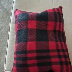 May include: Red and black plaid throw pillow with a soft, fuzzy texture.